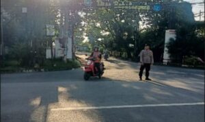 Polisi Tikung mengatur arus lalu lintas pagi di Simpang Tiga, menjaga ketertiban lalin.