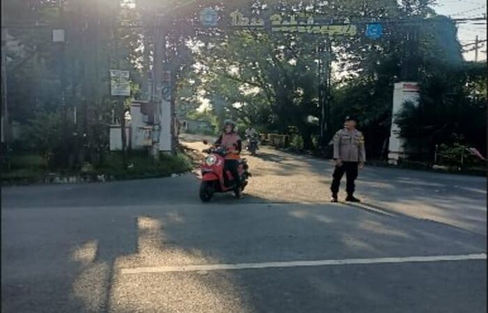Polisi Tikung mengatur arus lalu lintas pagi di Simpang Tiga, menjaga ketertiban lalin.