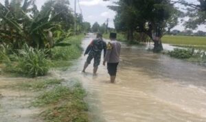 Polsek Tikung memantau genangan air di jalan raya akibat hujan lebat di Kecamatan Tikung Lamongan